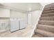 Practical laundry area with machines, tile floor, and access to the staircase at 235 S 8Th Ave, Brighton, CO 80601