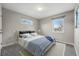 Cozy main bedroom with two big windows, a striped bedspread and wood accent nightstands at 4115 Zenobia St, Denver, CO 80212