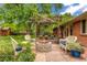 A beautiful backyard features stone patio with an outdoor fireplace and comfortable seating at 2775 Crabapple Rd, Golden, CO 80401