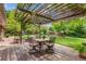 Backyard patio with vine covered pergola and outdoor dining area at 2775 Crabapple Rd, Golden, CO 80401