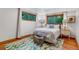 Bright bedroom with hardwood floors, area rug, and large windows overlooking mature trees at 2775 Crabapple Rd, Golden, CO 80401