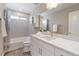 Bright bathroom featuring a shower-over-tub and vanity at 239 W Jamison Ct, Littleton, CO 80120