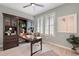 Office featuring built-in wooden shelves, a ceiling fan and natural light from the shuttered windows at 239 W Jamison Ct, Littleton, CO 80120