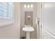 Well-lit powder room with a pedestal sink and neutral decor at 239 W Jamison Ct, Littleton, CO 80120