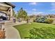 Expansive backyard with lush green grass and an outdoor patio ideal for entertaining or relaxation at 10492 Willowwisp Way, Highlands Ranch, CO 80126