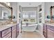 Bright bathroom boasts a freestanding tub, double vanities, and ample storage space at 10492 Willowwisp Way, Highlands Ranch, CO 80126