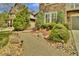 Landscaped front yard featuring a stone pathway, mature shrubs, and decorative rocks at 10492 Willowwisp Way, Highlands Ranch, CO 80126