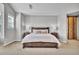 Neutral main bedroom features a bed, and a sliding wood door to the ensuite bathroom at 10492 Willowwisp Way, Highlands Ranch, CO 80126