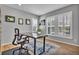 Bright home office with shuttered windows, a modern desk, and hardwood floors at 10492 Willowwisp Way, Highlands Ranch, CO 80126
