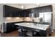 Modern kitchen features black cabinetry, stainless steel appliances, granite counters and pendant lighting at 336 E 1St Ave # 209, Denver, CO 80203
