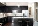 Well-equipped kitchen features black cabinetry, stainless appliances, and granite island with breakfast bar seating at 336 E 1St Ave # 209, Denver, CO 80203