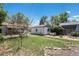 Spacious backyard with a detached garage, patio seating, and a charming swing set for outdoor enjoyment at 1979 Beeler St, Aurora, CO 80010