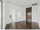 Minimalist bedroom with hardwood floors, a view to another room, and a dark wooden door at 55 W 12Th Ave # 512, Denver, CO 80204