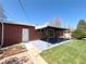 Brick home featuring covered patio, large, level backyard, mature trees, and landscaping at 2274 S Newton St, Denver, CO 80219