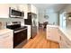 Modern kitchen with stainless steel appliances, white cabinets, hardwood floors, and quartz countertops at 2274 S Newton St, Denver, CO 80219