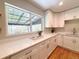 Kitchen with white cabinets, quartz countertops, stainless steel appliances, and natural lighting at 2274 S Newton St, Denver, CO 80219