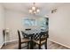 Cozy dining area with a modern chandelier, hardwood floors, and a lovely window view at 2900 Purcell St # I4, Brighton, CO 80601