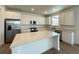 Bright, spacious kitchen with stainless steel appliances and a large center island at 586 Nightsky St, Erie, CO 80516