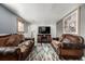 Finished basement featuring brown sofas and a large TV at 16357 E Wyoming Dr, Aurora, CO 80017