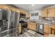 Modern kitchen with stainless steel appliances and wood cabinetry at 16357 E Wyoming Dr, Aurora, CO 80017