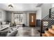 Bright living room with gray sofa, wood-look floors, and a modern staircase at 16357 E Wyoming Dr, Aurora, CO 80017