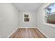 Empty room featuring neutral walls, wood flooring, and two windows at 851 S Eliot St, Denver, CO 80219