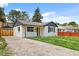 Quaint home with a gravel driveway and fresh green lawn at 851 S Eliot St, Denver, CO 80219