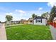 Landscaped front yard with lush green grass and mature trees on a sunny day at 851 S Eliot St, Denver, CO 80219