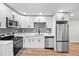Modern kitchen with stainless steel appliances, white cabinets, and subway tile backsplash at 851 S Eliot St, Denver, CO 80219