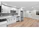 Open-concept kitchen with stainless steel appliances, gray subway tile backsplash and an adjacent dining area at 851 S Eliot St, Denver, CO 80219