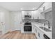 Well-lit kitchen featuring stainless steel appliances, white cabinets, gray subway tile backsplash and wood flooring at 851 S Eliot St, Denver, CO 80219