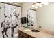 Bathroom with a vanity sink, decorative shower curtain, and unique elk and bird motif at 610 Meadow View Dr, Evergreen, CO 80439