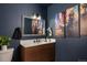 A stylish bathroom boasts a modern vanity with unique wood detail and eye-catching art at 610 Meadow View Dr, Evergreen, CO 80439