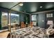A beautiful bedroom features dark walls, wood floors, a canopied bed, and mountain views from large windows at 610 Meadow View Dr, Evergreen, CO 80439