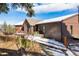 Charming exterior view of a brown home surrounded by a snow-covered landscape with red Adirondack chairs at 610 Meadow View Dr, Evergreen, CO 80439