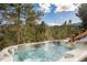 Outdoor hot tub with mountain views and surrounding evergreen trees offers a serene and private relaxation experience at 610 Meadow View Dr, Evergreen, CO 80439