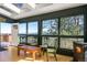 Inviting sunroom with natural light, charming chairs, wood burning stove, and stunning mountain views at 610 Meadow View Dr, Evergreen, CO 80439