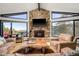 Relaxing living room with a stone fireplace, cozy seating, and panoramic views from expansive windows, offering natural light at 610 Meadow View Dr, Evergreen, CO 80439