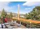 Outdoor dining area set for a meal with scenic views of the snow-dusted hillside at 610 Meadow View Dr, Evergreen, CO 80439