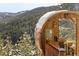 This outdoor barrel sauna blends rustic charm with scenic views of snow-covered pine trees and mountains at 610 Meadow View Dr, Evergreen, CO 80439
