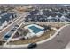 Aerial view of a community pool, clubhouse, playground, and parking at 7484 W Atlantic Ln, Denver, CO 80227