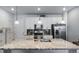 Spacious kitchen with a large island, stainless steel appliances, and stylish pendant lighting at 7484 W Atlantic Ln, Denver, CO 80227