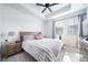 Bright and airy main bedroom features a ceiling fan and a window with a view at 7484 W Atlantic Ln, Denver, CO 80227