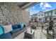 Cozy porch featuring a stone wall, comfortable seating, and a view of the neighborhood at 7484 W Atlantic Ln, Denver, CO 80227