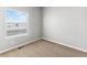A bright bedroom with neutral carpet, a window with blinds and base trim throughout at 869 Sawdust Dr, Brighton, CO 80601