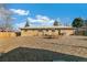 View of the home's spacious backyard with a wood-chip groundcover, outdoor seating, and a grill at 6581 S Logan St, Centennial, CO 80121