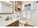 Well-lit bathroom with white tile, dark wood vanity, and shower/tub combo at 6581 S Logan St, Centennial, CO 80121