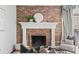 Close-up of the living room fireplace with a brick surround and decorative mantle at 700 N Washington St # 502, Denver, CO 80203