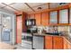Cozy kitchen featuring wood cabinetry, stainless steel appliances, and a balcony view at 700 N Washington St # 502, Denver, CO 80203