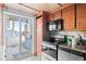 Functional kitchen with wooden cabinets, stainless steel appliances, and balcony access at 700 N Washington St # 502, Denver, CO 80203